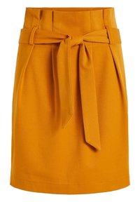 Jupe jaune ceinturée avec une taille haute, des plis et un tissu texturé. La ceinture est nouée à l'avant, créant une silhouette ajustée.