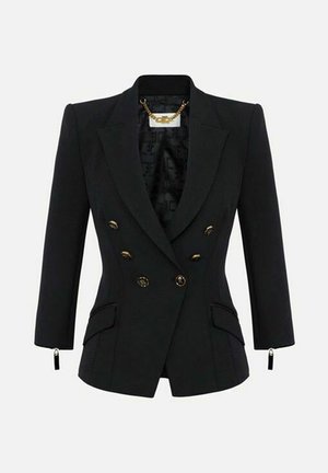 Blazer nero su misura con chiusura doppiopetto con bottoni dorati, spalle strutturate, maniche a tre quarti e tasche con patta davanti.