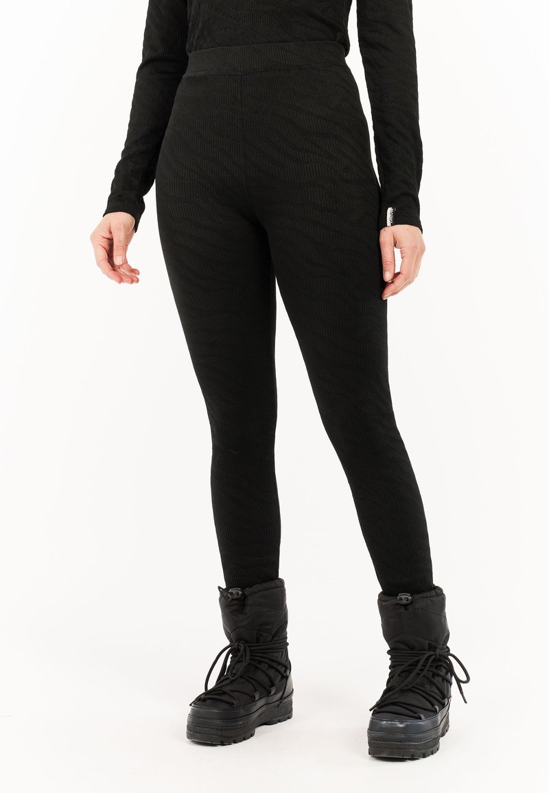 Svarta leggings med ett texturerat zicksackmönster, hög midja och smal passform. Matchas med knähöga svarta vinterstövlar.