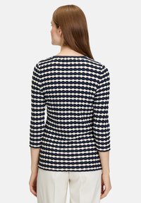 Gestreiftes Langarmoberteil in Marineblau und Creme mit einem strukturierten Wellenmuster und einem runden Halsausschnitt, in taillierter Passform.