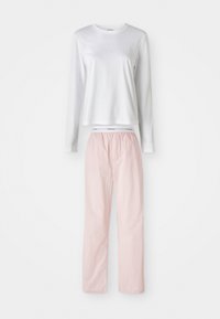 Långärmad vit topp med "Calvin Klein"-logotyp och ljusrosa byxor, visad mot en ren bakgrund.