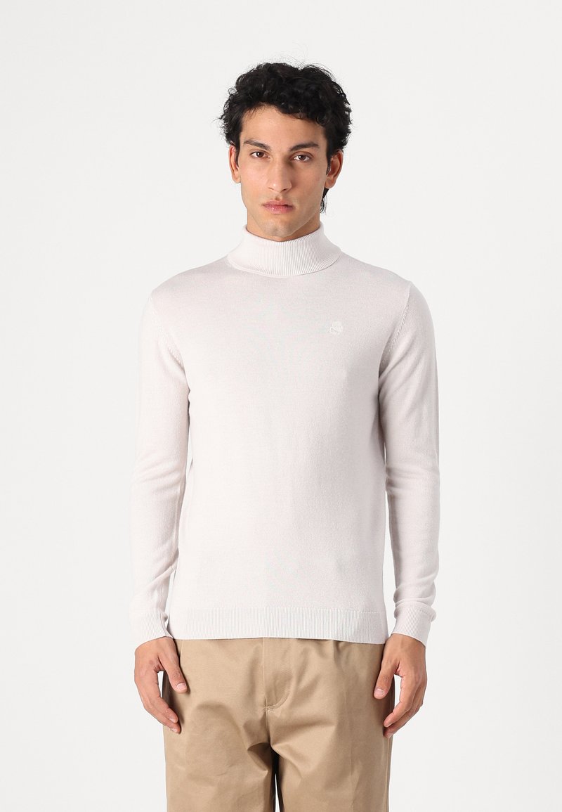 Hellbeige Rollkragenpullover aus weichem Material, mit langen Ärmeln und geripptem Saum, versehen mit einem kleinen Logo auf der Brust.