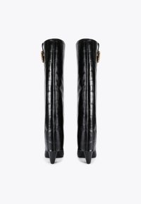 Wysokie czarne skórzane botki o fakturze krokodyla, wyposażone w złotą klamrę po boku i szpiczaste obcasy.