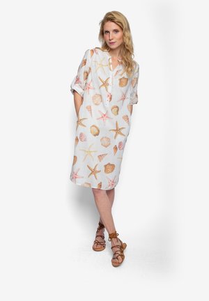 Lekka lniana sukienka z wzorami muszelek i rozgwiazd w pastelowych kolorach. Posiada kołnierzyk, patkę na guziki oraz krótkie, podwijane rękawy.
