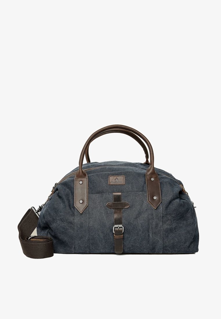 Torba podróżna z płótna w ciemnoniebieskim kolorze z brązowymi skórzanymi akcentami, podwójnymi uchwytami, regulowanym paskiem na ramię oraz centralnym zdobieniem w postaci klamry.