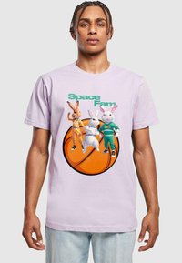 Gaiši violets kokvilnas T-krekls ar karikatūras zaķiem sporta apģērba tērpā, uzdrukāts ar "Space Fam" un basketbola ilustrāciju.