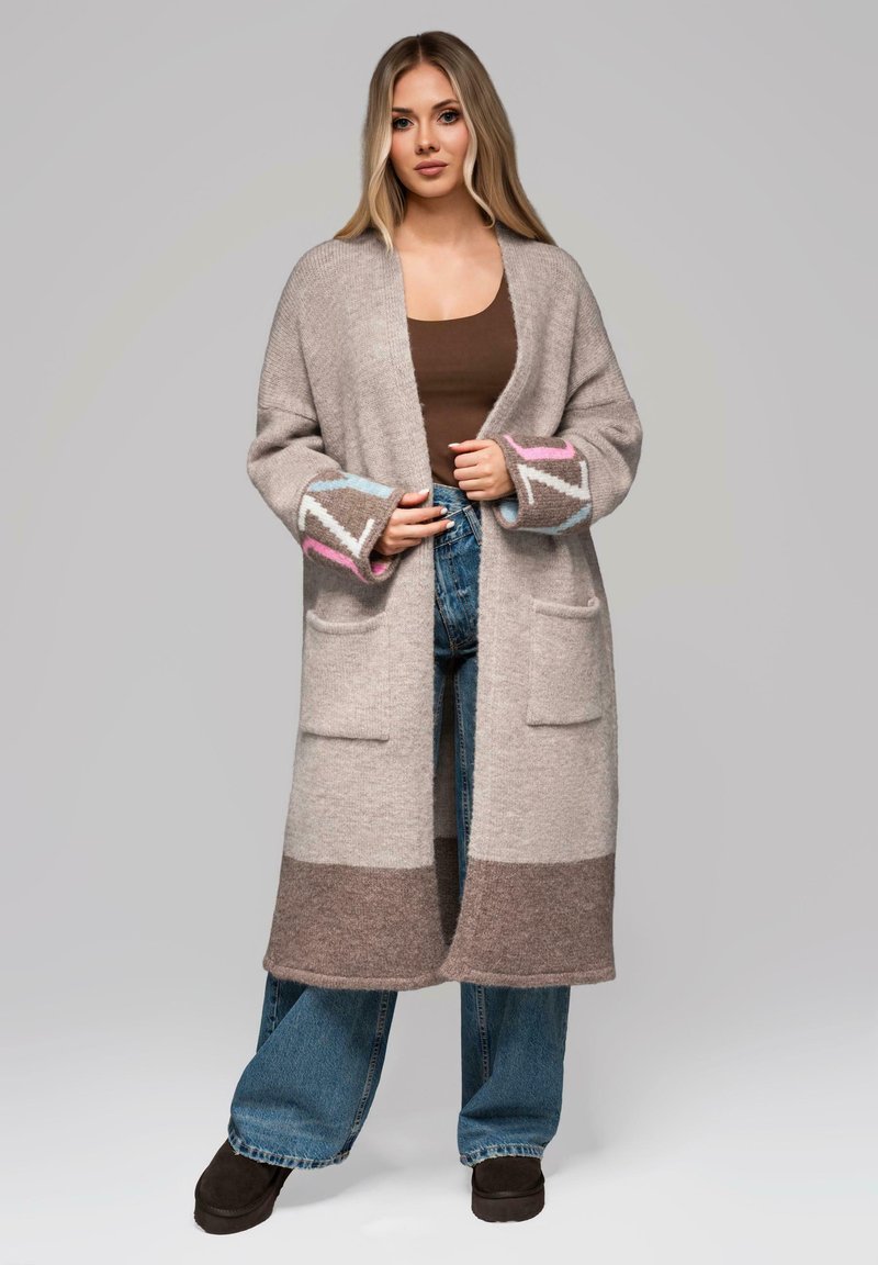 Cardigan lungo lavorato a maglia in grigio chiaro con strisce marroni e crema, con dettagli rosa e blu sui polsini e due tasche frontali.