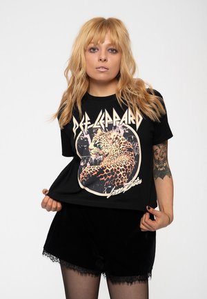 Black cotton t-shirt featuring a leopard graphic and "Def Leppard" text. The shirt has a relaxed fit with short sleeves.