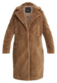Abrigo teddy largo marrón con solapas anchas, mangas largas y bolsillos laterales, con un forro interior suave y una etiqueta de marca negra.