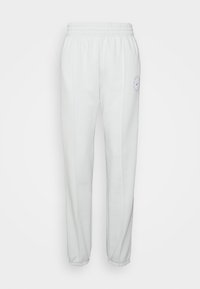 Vita sweatpants med elastisk midja och smalnande anklar, med en blå cirkulär logotyp på vänster lår och diskreta sid sömmar.