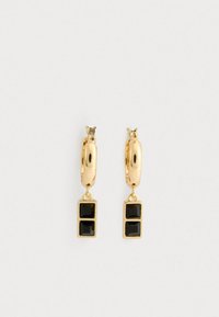 Orecchini a cerchio in oro con due pietre quadrate nere che pendono sottostanti, caratterizzati da una texture liscia e un design classico.