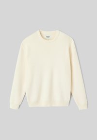 Pull en tricot léger de couleur crème avec un col rond, des poignets et un ourlet côtelés. Caractérisé par une texture douce et une coupe décontractée. Étiquette de marque visible.