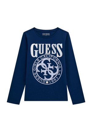 Maglietta a maniche lunghe di colore navy realizzata in cotone biologico. Presenta grande testo bianco "GUESS" e un design circolare del logo. Collo rotondo classico.