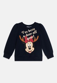 Tumesinine dressipluus pikade varrukatega, elastsete mansettidega, millel on koomiksitegelane sarvedega ja punase lipsuga. Tekst ütleb: "Olen olnud kogu aasta jäär!"