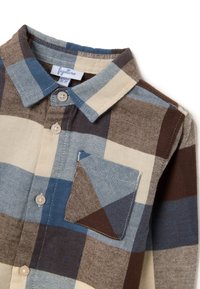 Camisa de botones con un patrón de cuadros en azul, marrón y crema. Cuenta con un cuello, un bolsillo en el frente y botones beige en una tela suave.