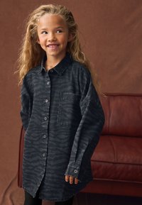 Camicia in denim scuro con un sottile motivo a zebra, con chiusura frontale con bottoni, collo con risvolto e taschino sul petto. Adatta per un abbigliamento casual.