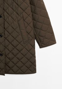 Prošívaný hnědý kabát s diamantovým vzorem, vybavený předním zapínáním na knoflíky, boční kapsou a rovnou spodní částí.