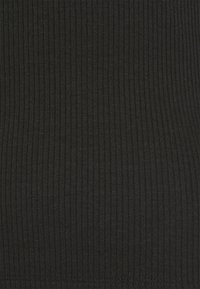 Żebrowany czarny materiał o gładkiej teksturze. Posiada pionowe linie, równomierne szwy wzdłuż brzegów i lekki wygląd.