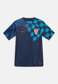 Maillot de football bleu foncé avec un motif à carreaux bleu clair sur l'épaule droite, virgule rouge de Nike et insigne de football croate sur la poitrine.