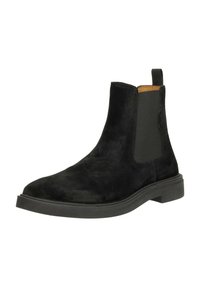 Botte de cheville en daim noir avec des panneaux latéraux élastiques, bout arrondi et semelle en caoutchouc plate. Dispose d'une tirette à l'arrière pour un enfilage facile.