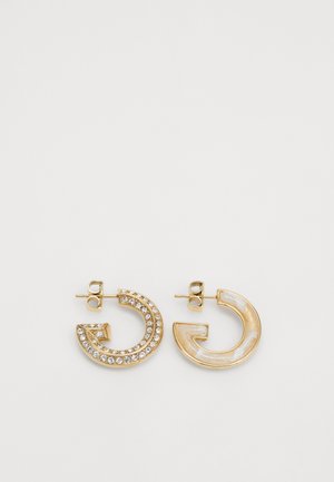 Gold-tone earrings featuring a circular design, one embellished with clear crystals and the other in a glossy cream finish with marbled texture.