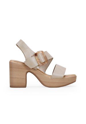 Beige leather platform sandals with a wooden block heel, featuring a wide strap with a transparent buckle accent and an open toe design.