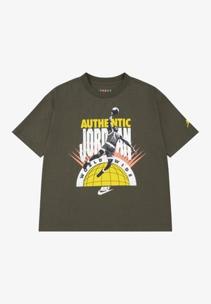 Maglietta verde oliva con grafica di un giocatore di basket che schiaccia, testo "AUTHENTIC JORDAN WORLDWIDE" e logo Nike giallo.