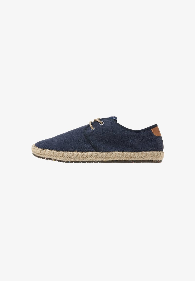 Espadrille en toile bleu marine avec une finition texturée, semelle en jute, accent tan contrastant au talon et fermeture à lacets.