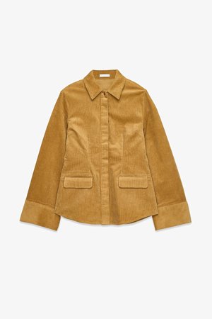 Veste en velours côtelé jaune moutarde avec un col, fermeture éclair sur le devant, deux poches poitrine et des manches large à revers.