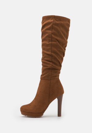 Botte haute jusqu'au genou en daim marron avec tige froncée, semelle plateforme et talon haut à empilement.