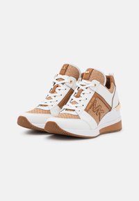 Sneaker bianca e beige con tomaia in rete, dettagli in pelle, logo dorato e suola testurizzata. Presenta lacci rotondi e collare imbottito.
