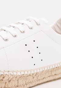 Vit läder espadrille sneakers med rund tå, metallöglor och mellansula av jute-rep. Har perforerade detaljer på sidan.