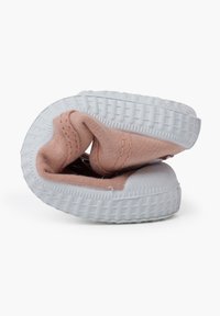 Sneaker pliée avec une tige en toile rose, semelle en caoutchouc blanc, semelle texturée et détails de couture à l'ouverture et sur les côtés.