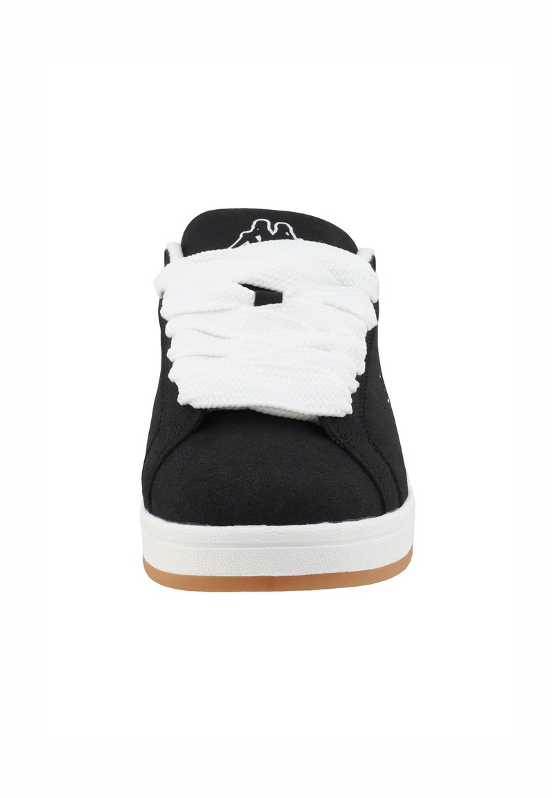 Zapatillas de ante negras con cordones blancos, suela blanca y suela de goma marrón. Presenta un logo en la lengüeta y una textura suave.