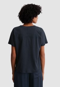 Dark blue, short-sleeve cotton T-shirt featuring a round neckline and a subtle seam detail across the back. Soft, relaxed fit.