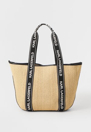 Große geflochtene Strohtasche mit schwarzen Stoffgriffen, die den Text "KARL LAGERFELD" zeigt. Rundliche Form, strukturierte Oberfläche und schwarzer Besatz.