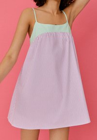 Robe rayée avec un corsage vert clair et des rayures horizontales roses ; possède des fines bretelles et une silhouette ample et fluide.