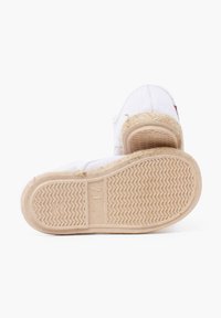 Valged kanvas espadrillid tekstureeritud tallaga, beeži jute detailiga ja minimaalse õmblusega. Talla pinnal on laineline muster. Suuruse silt on nähtav.