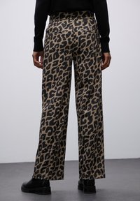 Leopardenmuster weite Hosen aus braunem und schwarzem Stoff. Mit hoch sitzendem Bund und zwei Gesäßtaschen. Glatter Stoff mit lockerer Passform.