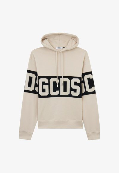 Beige huppari, jossa musta vaakasuora raita rinnassa ja hihoissa, ja suuret valkoiset "GCDS"-kirjaimet.