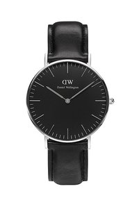 Black leather strap watch with a round silver case, featuring a matte black dial, silver hour markers, and minimalist design.