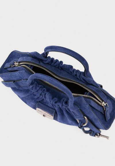 Sinine sametist käekott kogutud disainiga, kahe käepidemega ja hõbedase tõmblukuga sulguriga. Sisemus on mustast tekstiilist, brändi sildiga.