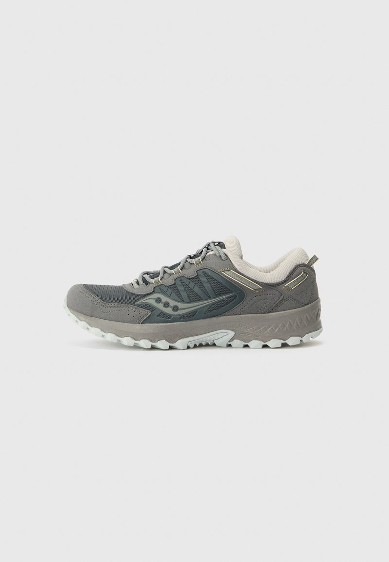 Chaussure de sport grise avec une tige texturée, des détails contrastants et une semelle en caoutchouc léger dotée de motifs de traction.