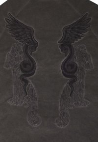 Schwarzes Ledergewebe mit filigraner Stickerei von geflügelten Figuren und Schlangen. Das Design enthält detaillierte Texturen und Muster.