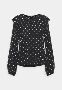 Blusa nera a maniche lunghe con pois bianchi, dettagli arricciati sulle spalle e polsini arricciati, esposta su uno sfondo bianco.