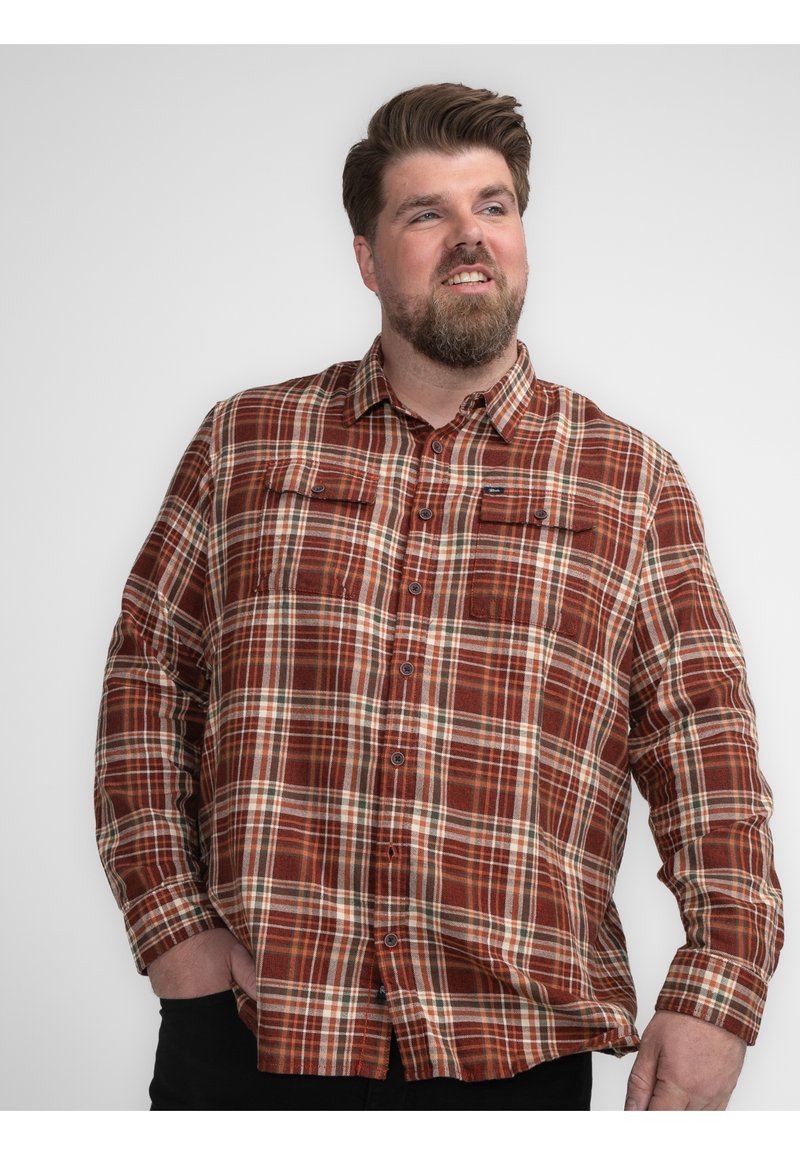 Geruite overhemd in bruin, oranje en crème tinten. Twee borstzakken met kleppen, lange mouwen en een kraag. Zachte textuur.