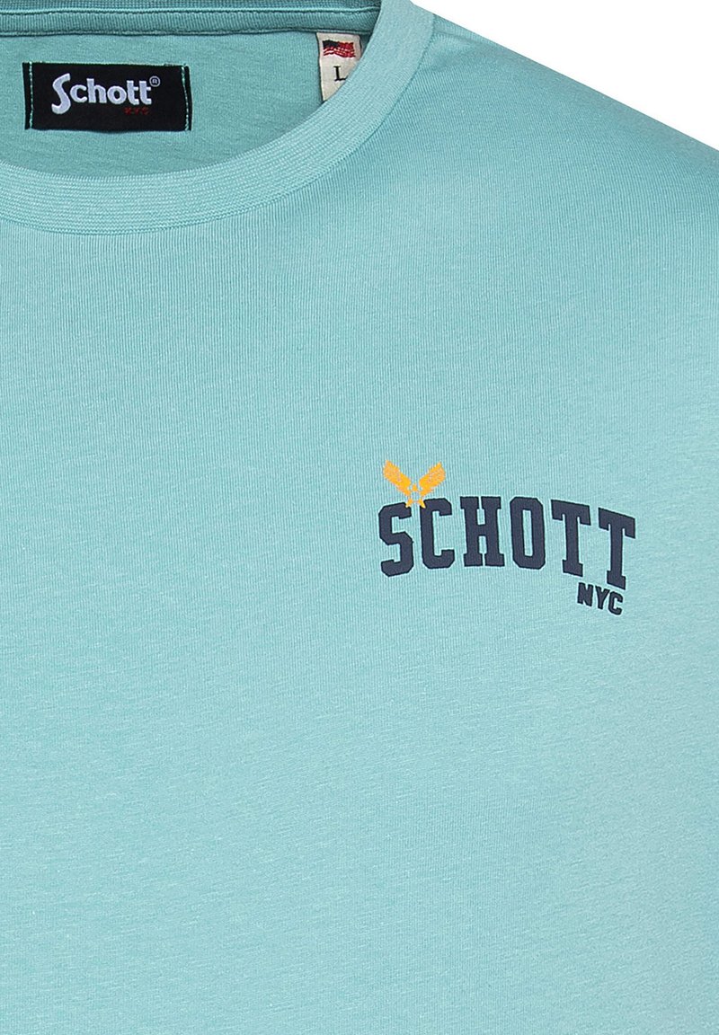 Camiseta de algodón de mangas cortas de color azul claro. Presenta un cuello redondo y la palabra "SCHOTT" en azul marino con un logo de acento naranja.