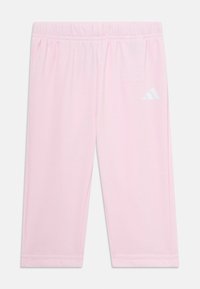 Leggings roses avec une ceinture élastique, fabriqués en tissu doux. Présence d'un logo Adidas blanc sur le côté gauche. Coupe simple et droite.