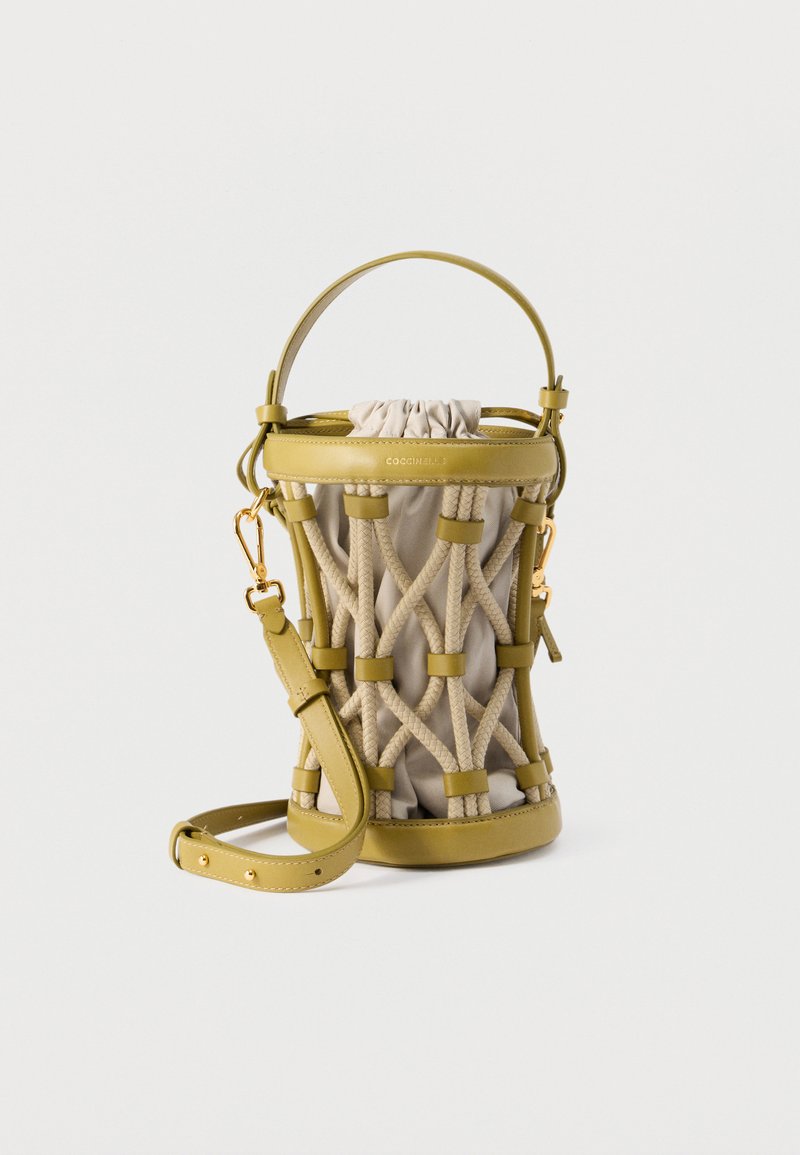 Κίτρινη δερμάτινη τσάντα κουβάς με μπεζ υφασμάτινη επένδυση και σχέδιο από πλεξούδα χοντρής σχοινιάς, με χειρολαβή στην κορυφή και ρυθμιζόμενο ιμάντα ώμου.