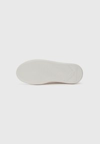 White rubber shoe sole with a textured design featuring wavy grooves and a prominent 'K' logo on the side. Smooth finish, no additional accents.